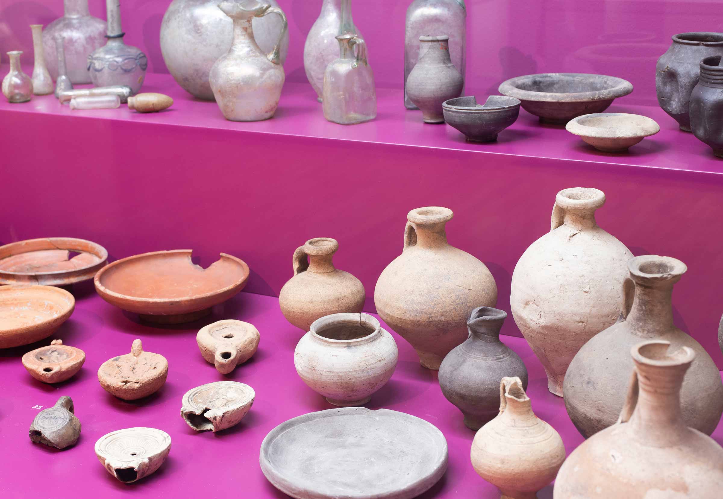 Eine Sammlung alter Keramikgefäße auf verschieden hohen Podesten